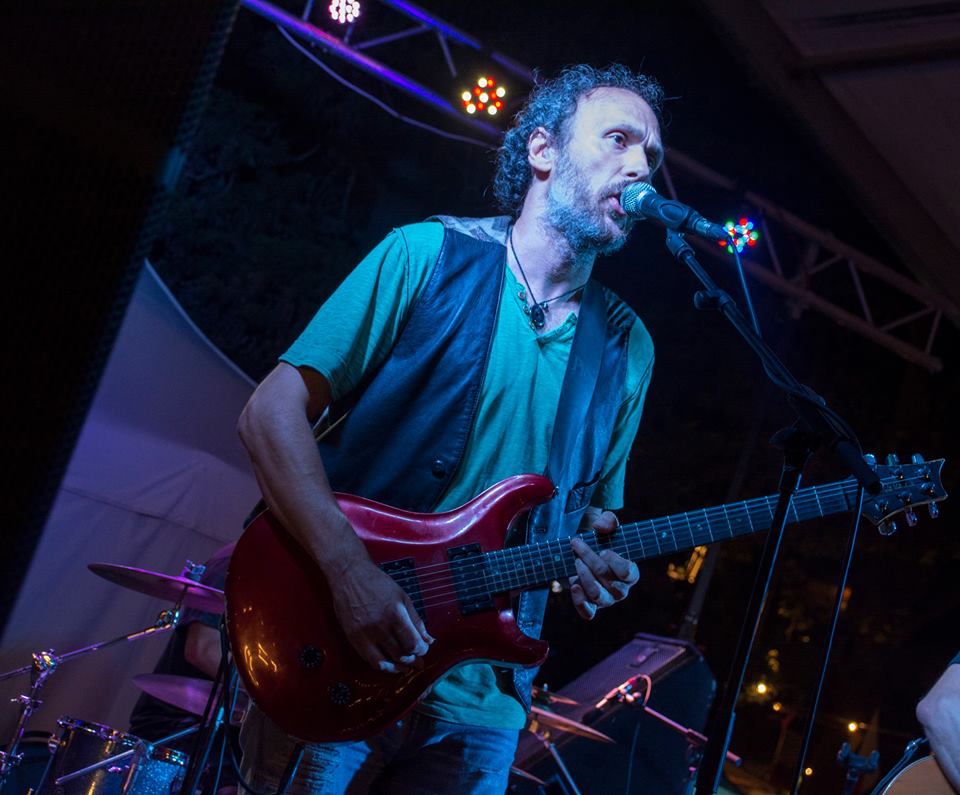 El profesor Tony Hernandez en uno de sus conciertos al aire libre tocando una guitarra